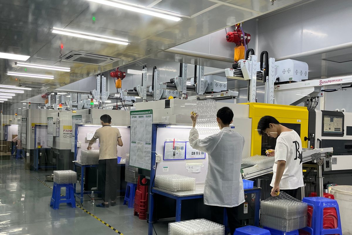 Injection molding shop with robot take-out arms, anti-dust enclosure and operators inspecting molded parts