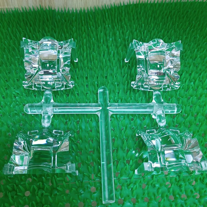 Transparent molded acrylic parts with a sprue on a green surface
