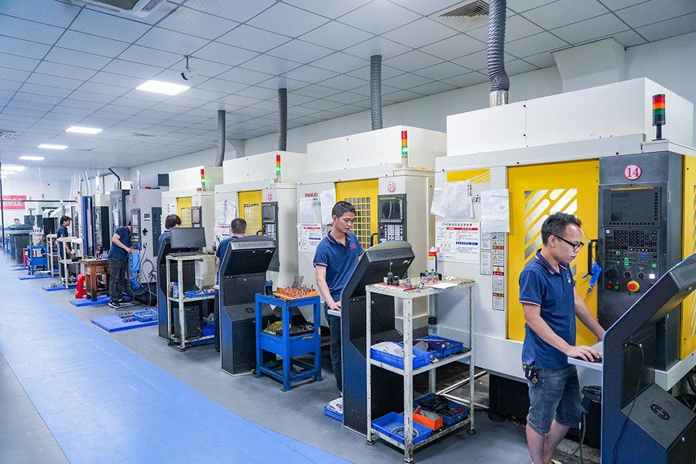 Rows of imported FANUC machining centres on the CENTS mold shop floor with operators at the controls
